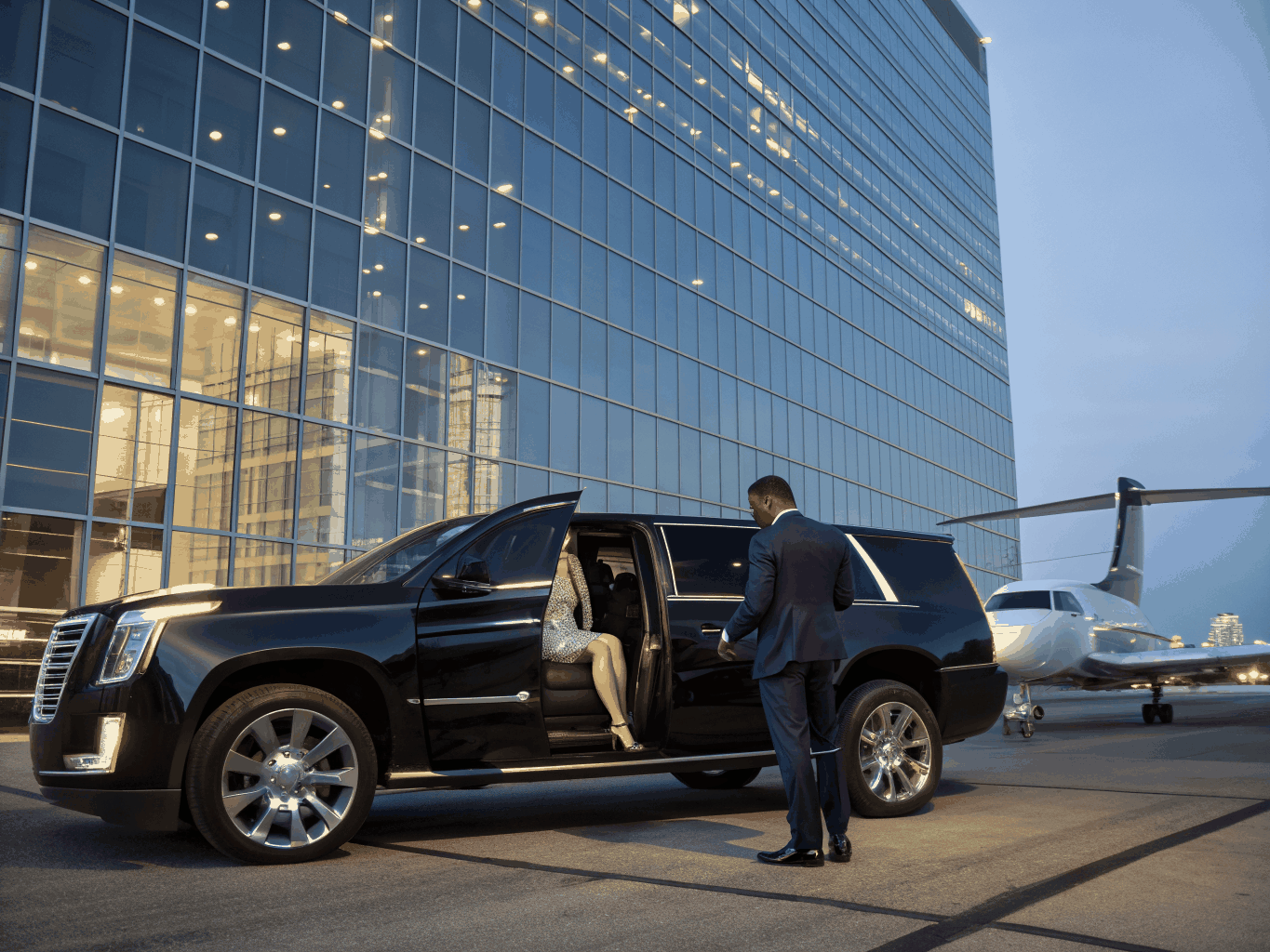 VIP chauffeur holding open door for executive client